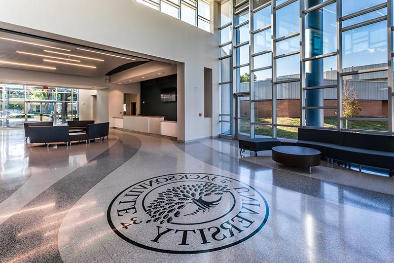 弗里希欢迎中心大厅，杰克逊维尔大学的标志镶嵌在水磨石地板上